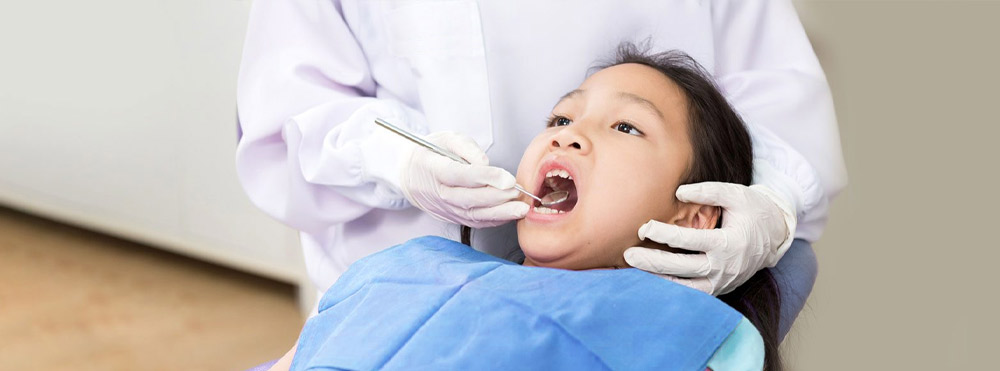 child in dentist chair getting flouride