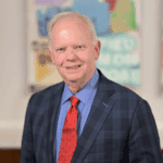 Smiling orthodontist in blue suit and red tie at Atlanta office